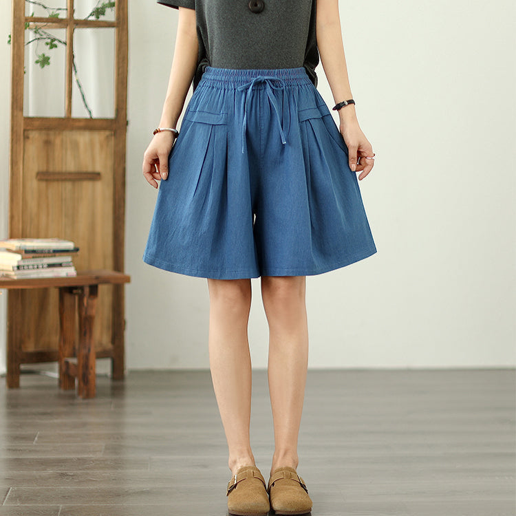 Person wearing a blue skirt in a minimal indoor setting