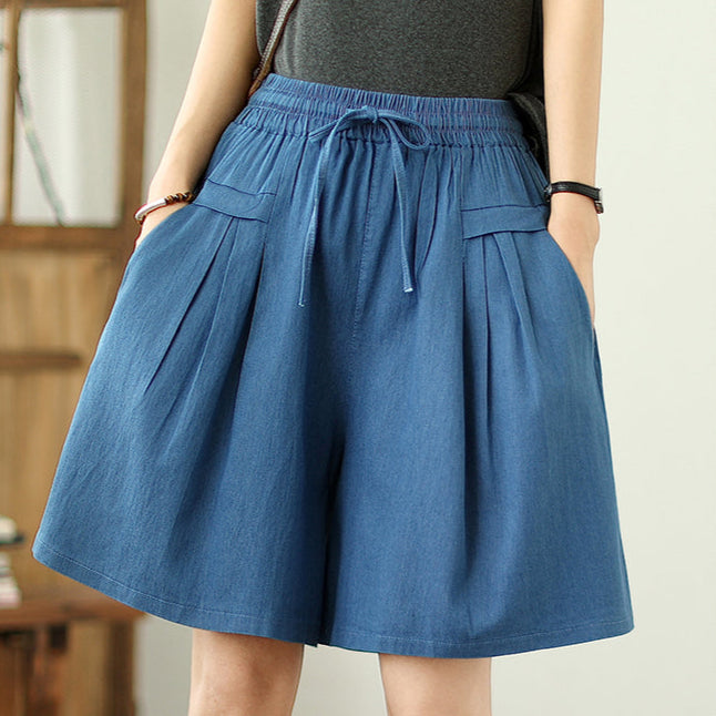 Blue denim shorts worn by a person with a neutral background