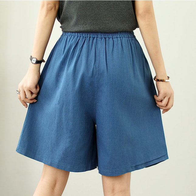 Person wearing blue shorts on a plain background