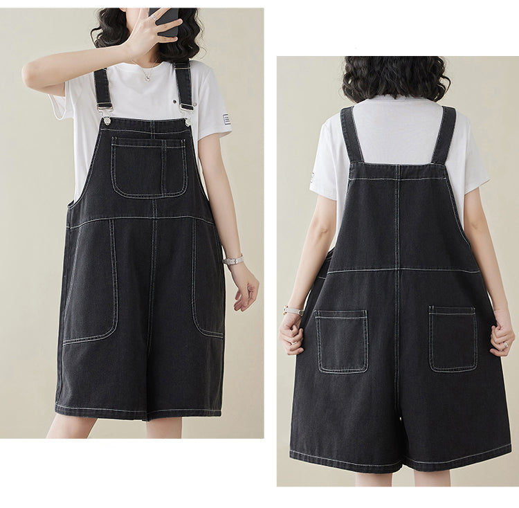 Black denim overalls worn by a person on a plain background