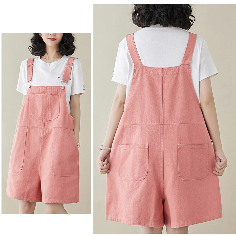 Pink denim overall dress worn by a person on a plain background