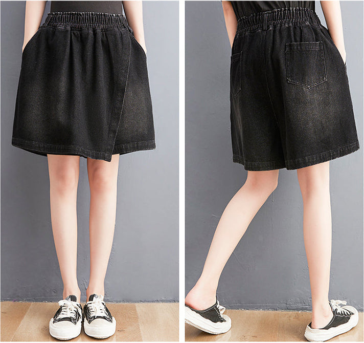 Black denim skirt worn by a person on a plain background