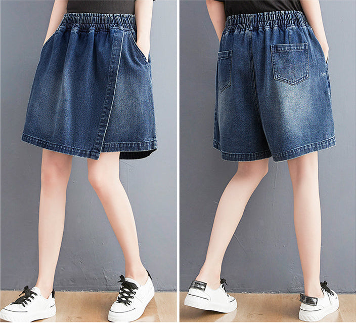 Denim shorts worn by a person on a plain background