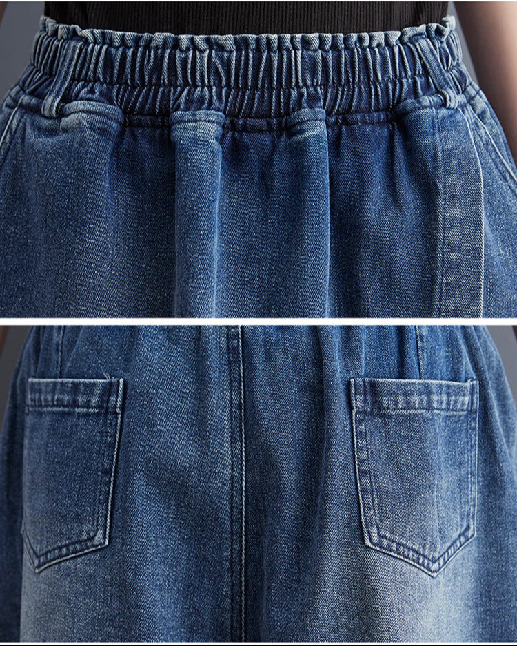 Close-up of blue denim pants with elastic waistband and front pockets.