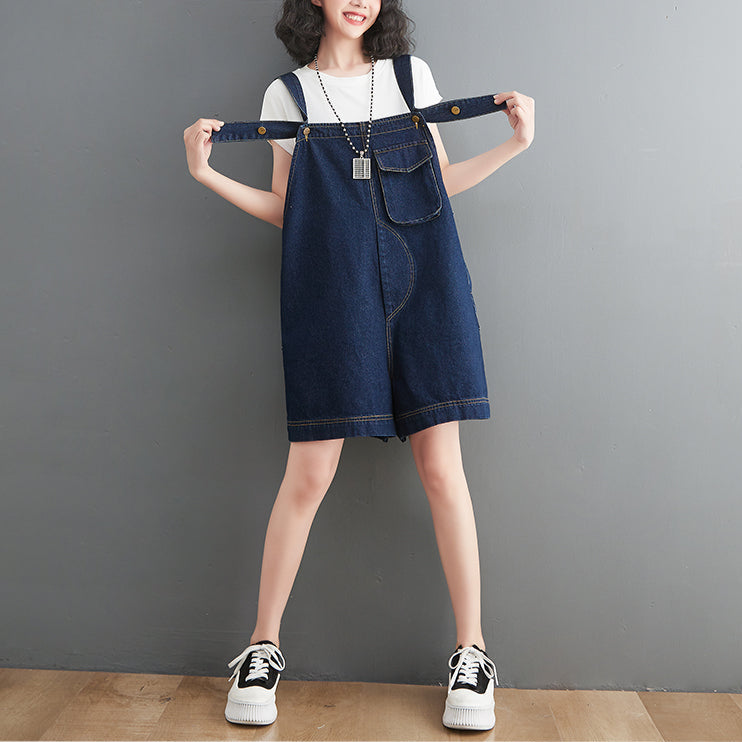 Woman wearing a denim dress against a gray background