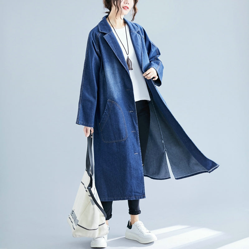 Person wearing a long blue denim coat on a light gray background