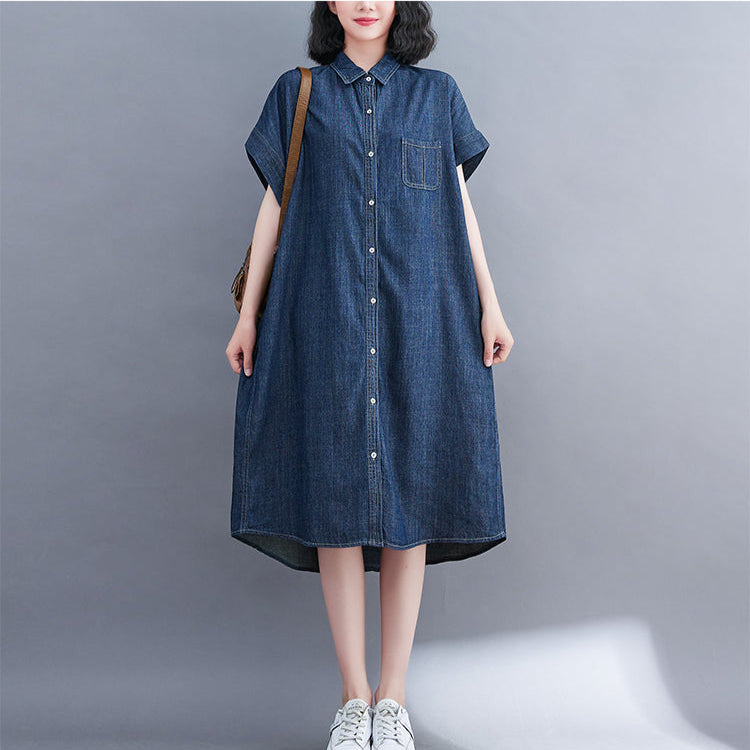 Woman wearing a blue denim dress on a gray background