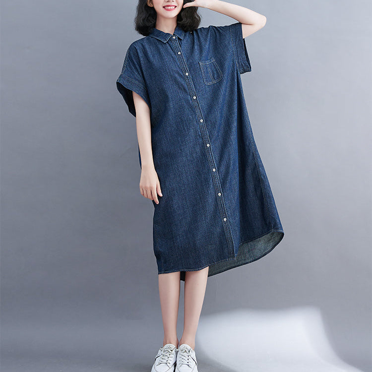 Woman wearing a blue denim dress against a gray background