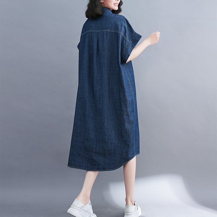 Person wearing a blue denim dress on a gray background