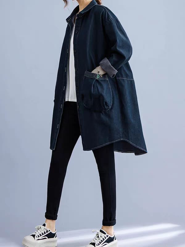 Person wearing a dark blue coat with a plain background