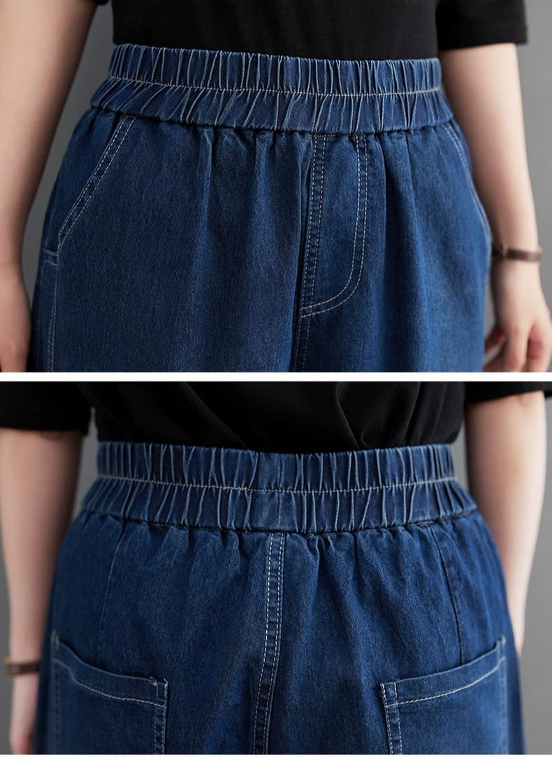 Close-up of a person wearing a blue denim skirt with an elastic waistband.