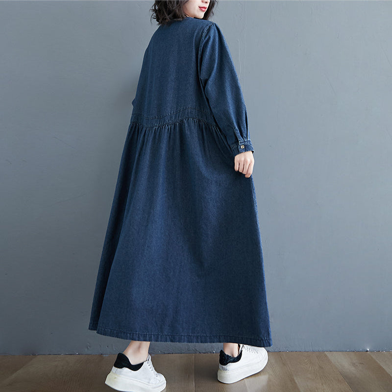 Person wearing a long blue dress against a gray background
