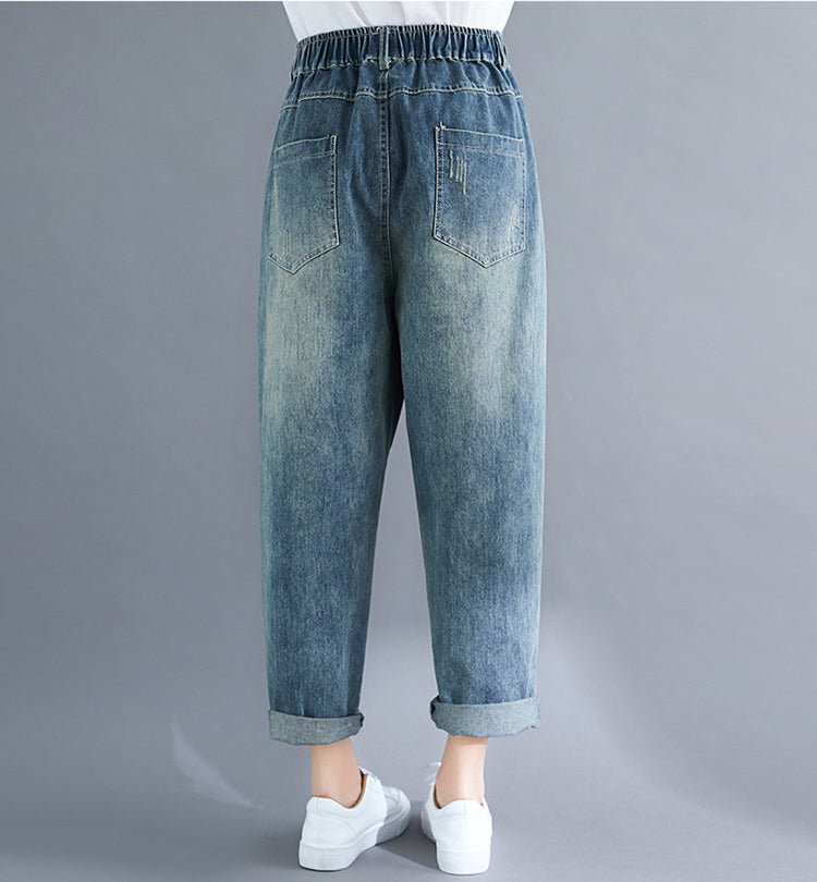 Blue denim jeans worn by a person on a gray background