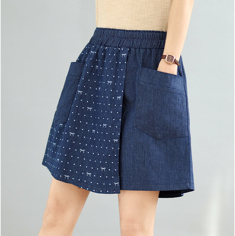 Blue denim skirt with white patterns on a gray background