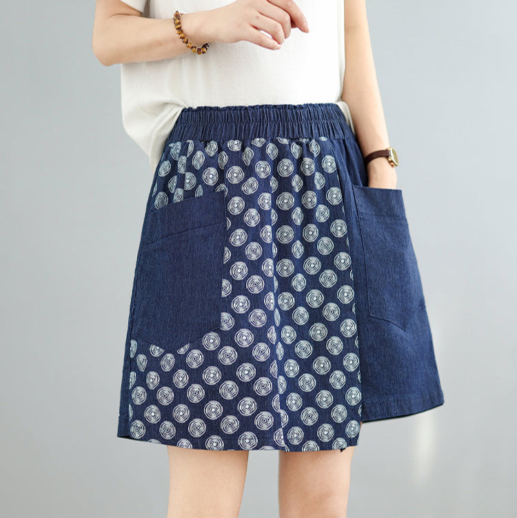 Blue patterned skirt worn by a person on a gray background