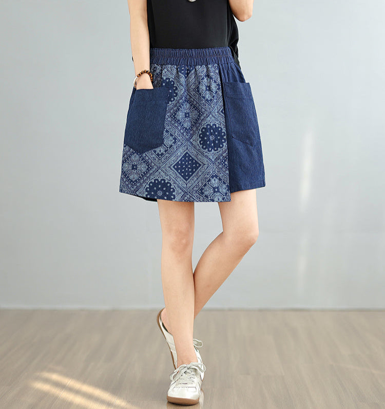 Person wearing a blue patterned skirt on a plain background