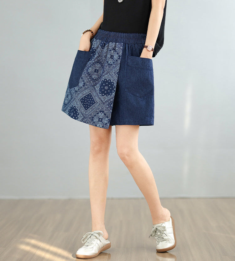 Person wearing a blue patterned skirt with a plain background