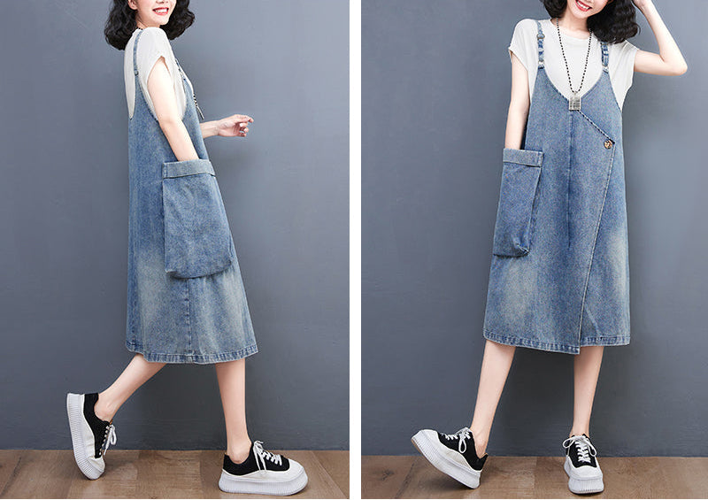 Denim pinafore dress worn by a person against a gray background