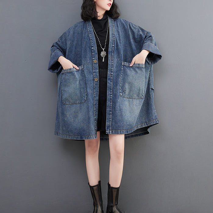 Person wearing a denim jacket against a gray background