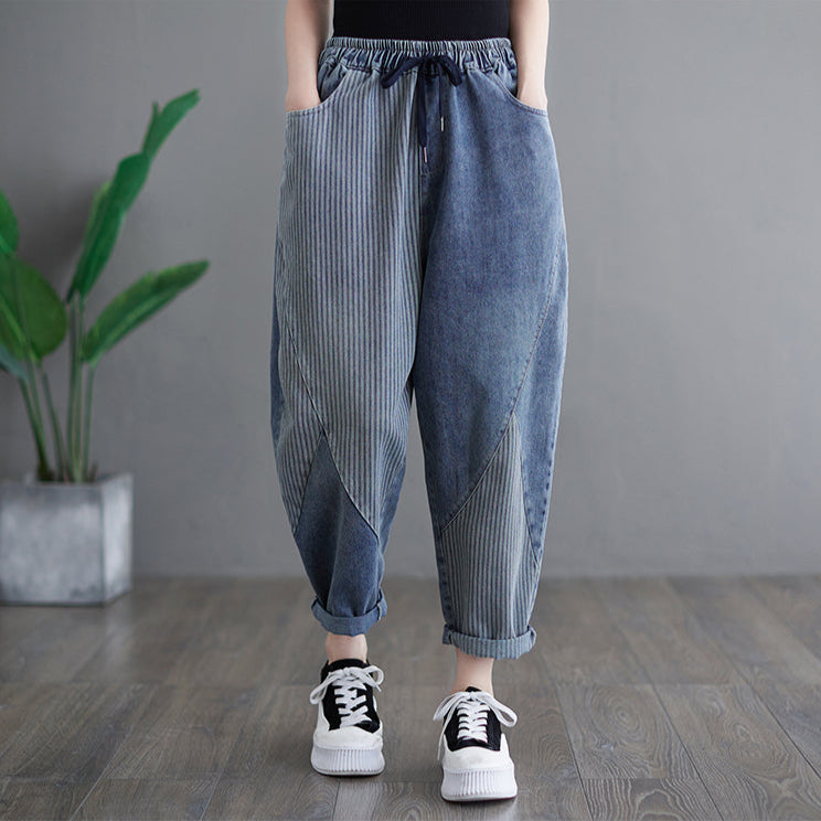 Person wearing blue striped pants with a gray background