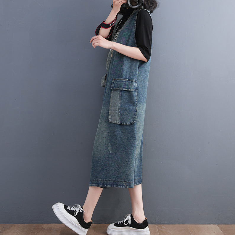Person wearing a denim dress with a plain background