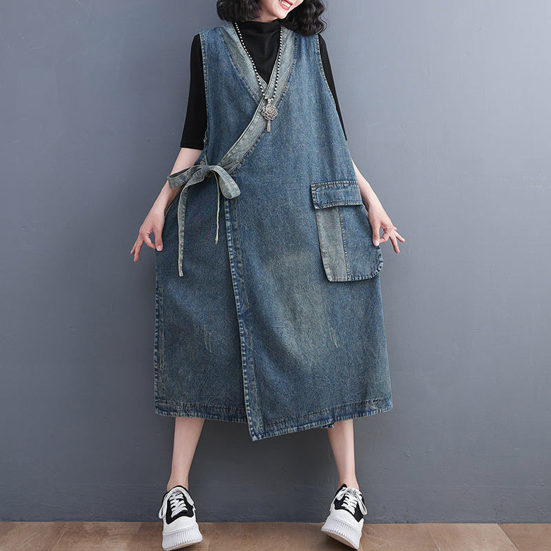 Person wearing a denim dress against a gray background