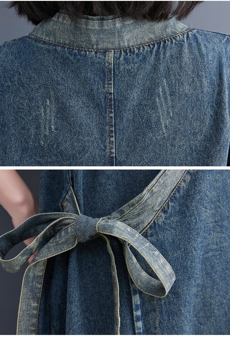 Close-up of a blue denim dress with a belt on a gray background
