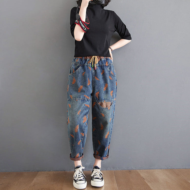Person wearing a black top and patterned jeans against a gray background with 'Gheongsam' branding.