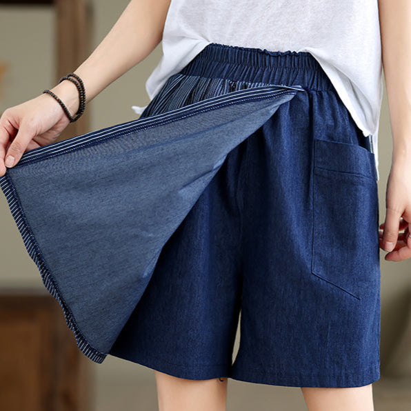 Person wearing blue shorts with a blurred background