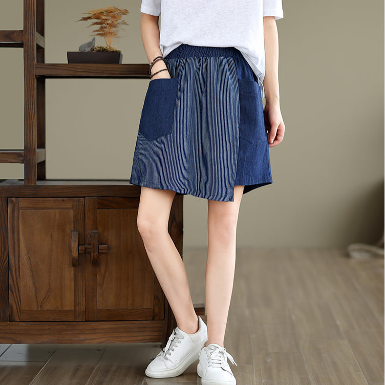 Person wearing a blue and white striped skirt in a room with wooden furniture.
