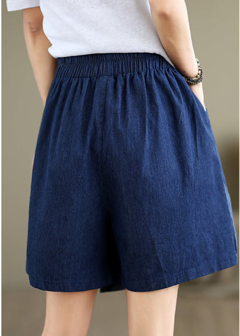 Person wearing a blue skirt with text and a teapot icon on a beige background