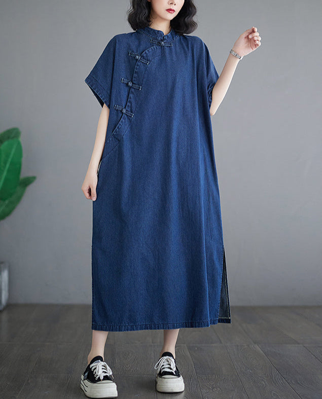 Woman wearing a blue denim dress with black and white sneakers on a gray background