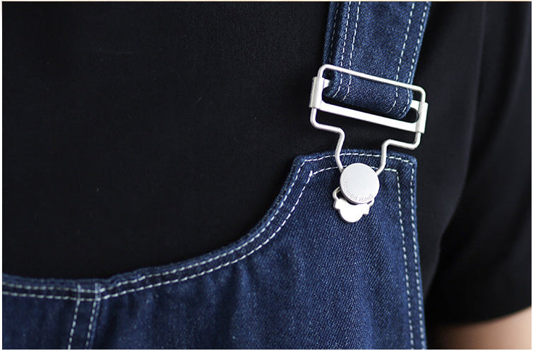 Close-up of a blue denim apron with a metal buckle on a black background