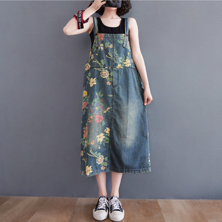 Person wearing a floral denim dress against a plain background