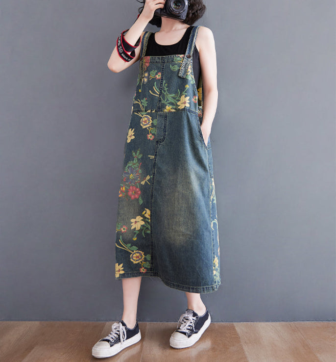 Person wearing a floral denim overalls against a plain background