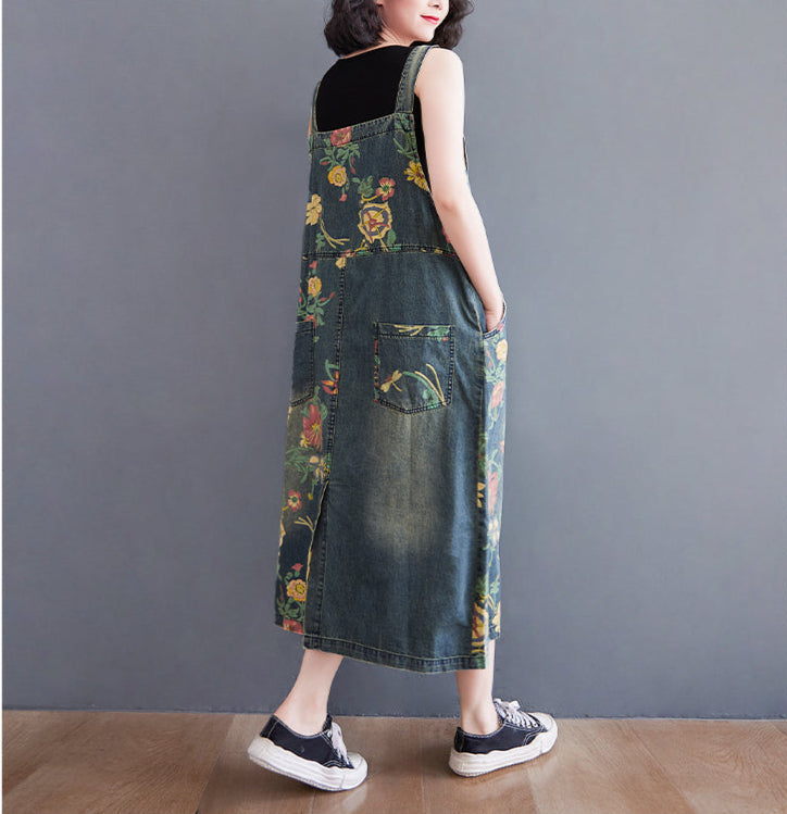 Person wearing a floral denim dress against a gray background