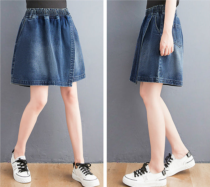 Denim skirt worn by a person on a plain background