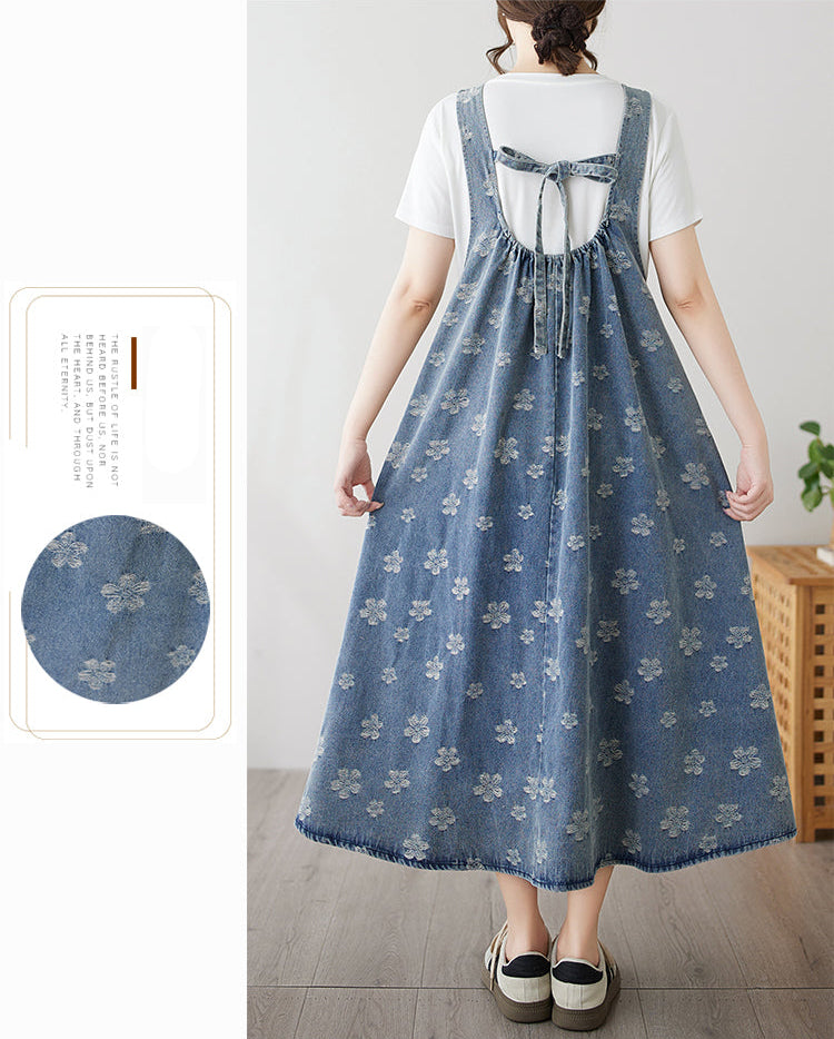 Woman wearing a blue floral denim dress with a white background