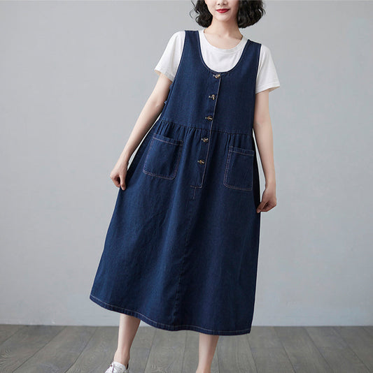 Woman wearing a blue denim dress over a white shirt on a plain background