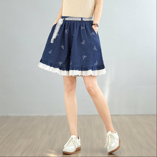Person wearing a blue denim skirt with white lace trim on a plain background