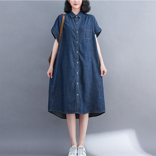 Woman wearing a blue denim dress on a gray background