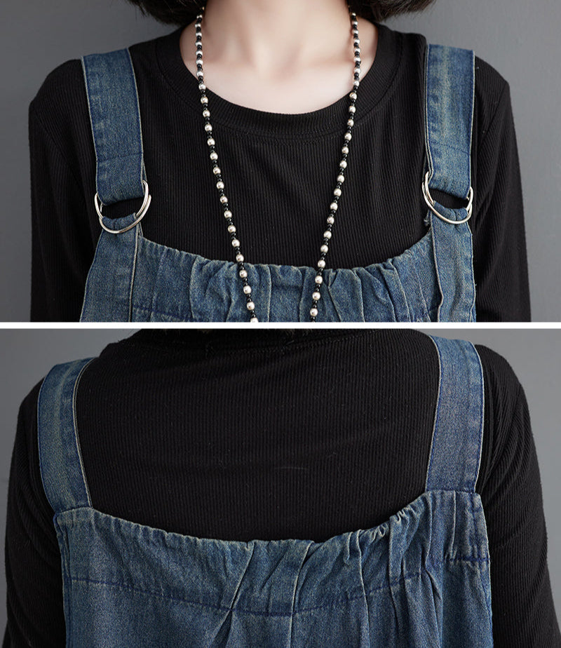 Person wearing a black top and denim overalls with a long necklace.
