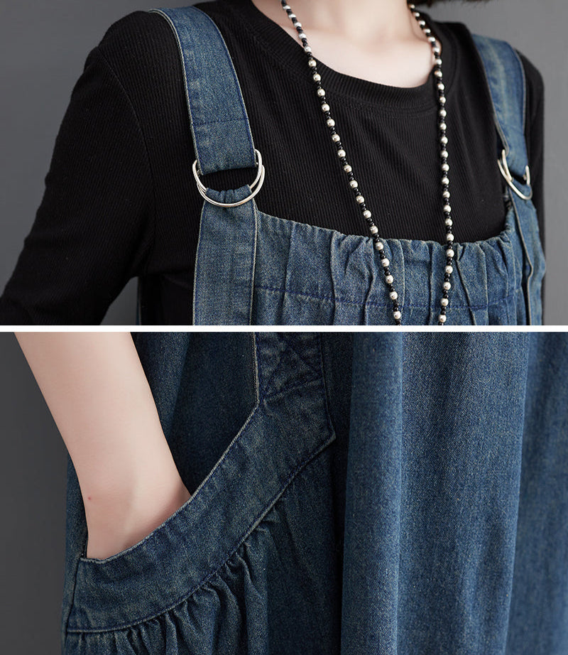 Person wearing a black top and blue denim overalls with a long necklace.