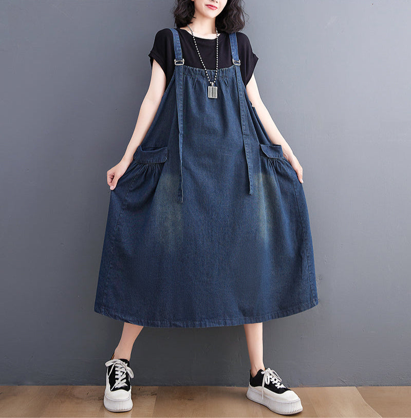 Person wearing a denim dress against a gray background