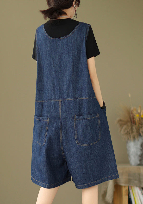 Person wearing a denim overalls with a plain background