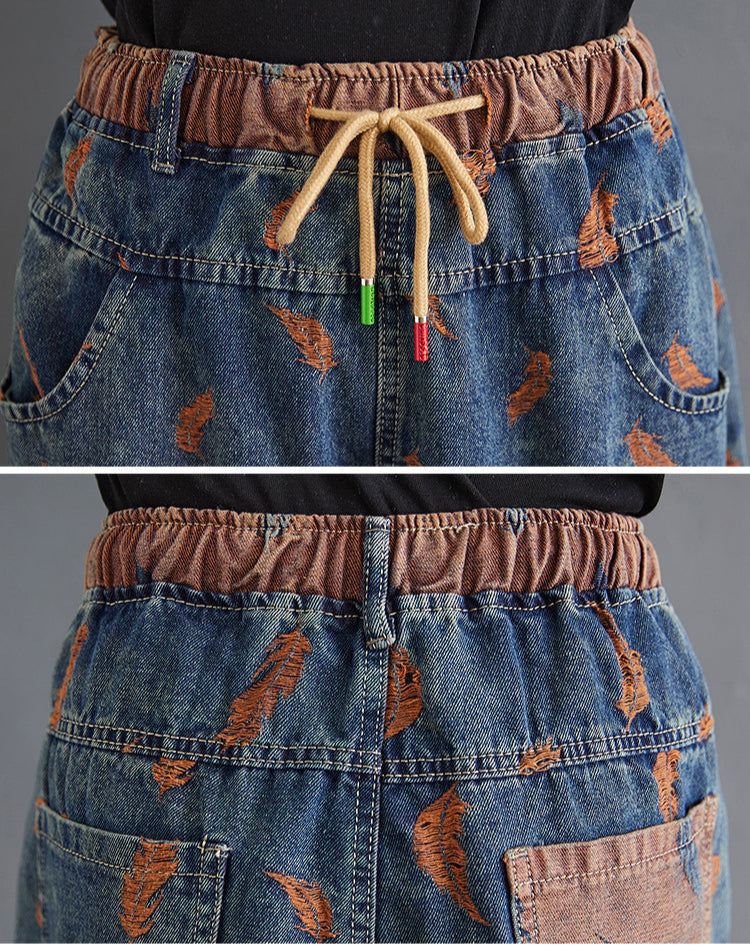 Close-up of a denim skirt with a brown belt and feather pattern, featuring the brand 'Gheongsam'.